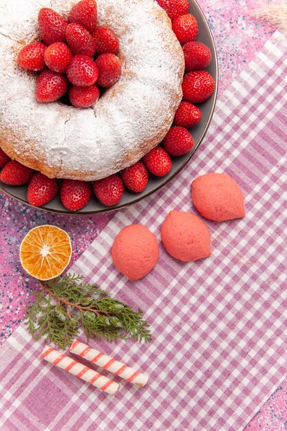 Draufsichtzuckerpulver-erdbeerkuchen auf dem rosa