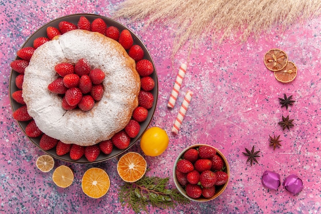 Draufsichtzuckerpulver-erdbeerkuchen mit zitrone auf hellrosa