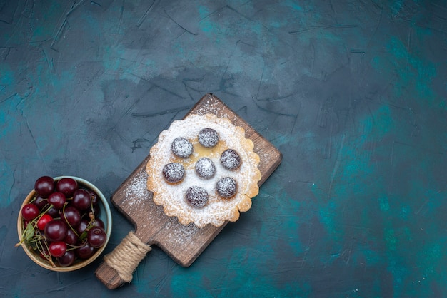 Draufsichtzuckerpulverkuchen mit sauerkirschen auf dem dunkelblauen hintergrundkuchenzuckersüßfruchtfarbfoto