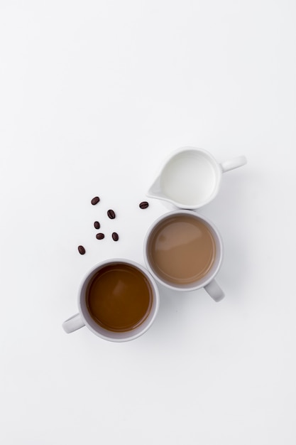 Draufsichtzusammenstellung mit Kaffeetassen und Milch