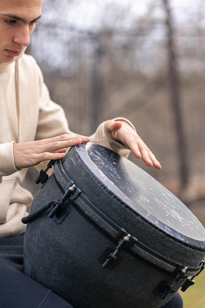 Draußen spielt ein Mann die Djembe-Trommel