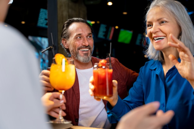 Drei ältere Freunde trinken und unterhalten sich in einem Restaurant