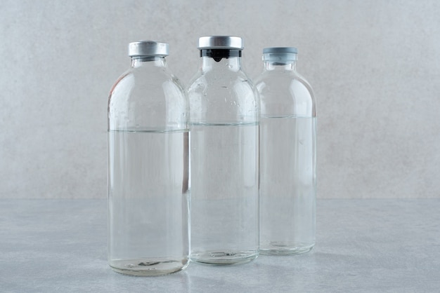 Drei Flaschen medizinisches Ethanol auf grauem Hintergrund. Foto in hoher Qualität