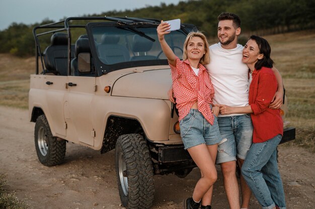 Drei Freunde, die Selfie nehmen, während sie mit dem Auto reisen