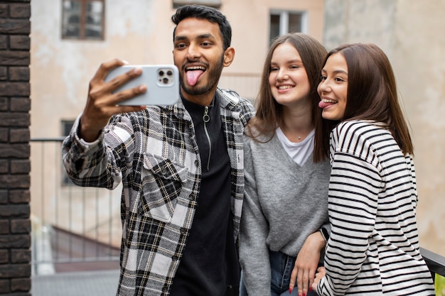 Drei Freunde machen ein Selfie mit herausgestreckter Zunge