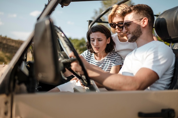 Drei Freunde überprüfen Karte während der Fahrt mit dem Auto