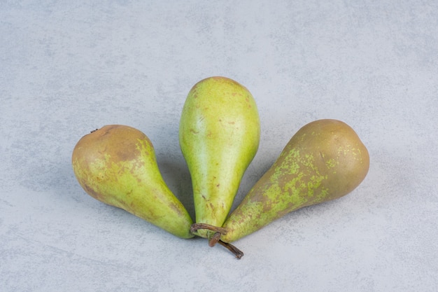 Drei frische Birne auf grauem Hintergrund.