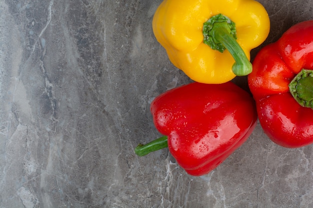 Drei ganze Paprika auf Marmorhintergrund