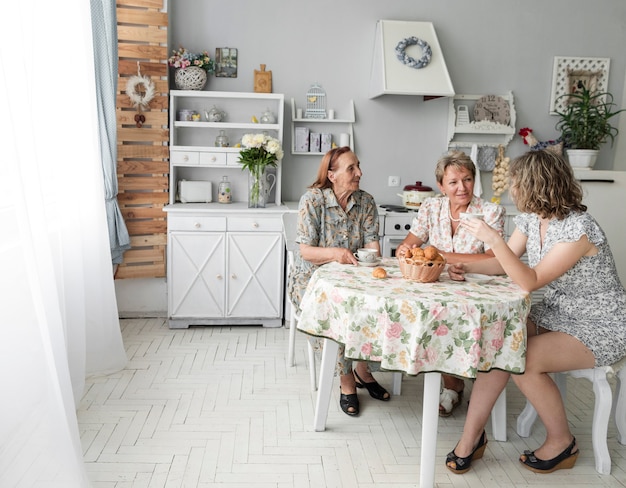 Drei Generationsfrauen, die etwas während des Frühstücks besprechen