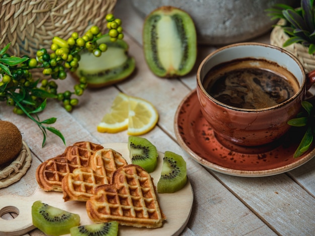 Drei herzförmige Waffeln mit Früchten und einer Tasse Espresso