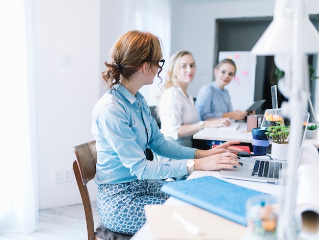 Drei junge Geschäftsfrauen, die im Büro sprechen