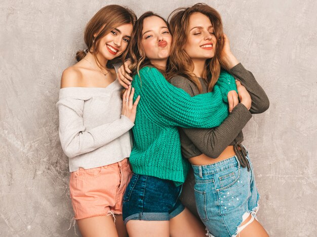 Drei junge schöne lächelnde herrliche Mädchen in der modischen Sommerkleidung. Sexy sorglose Frauenaufstellung. Positive Models, die Spaß haben