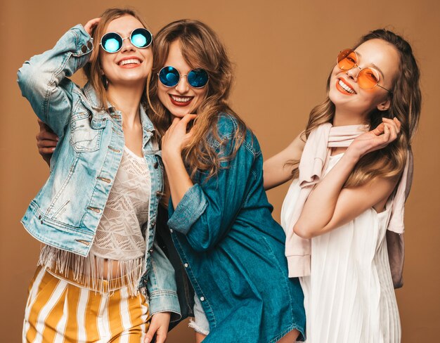 Drei junge schöne lächelnde Mädchen in der beiläufigen Kleidung des modischen Sommers. Sexy sorglose Frauenaufstellung. Positive Vorbilder