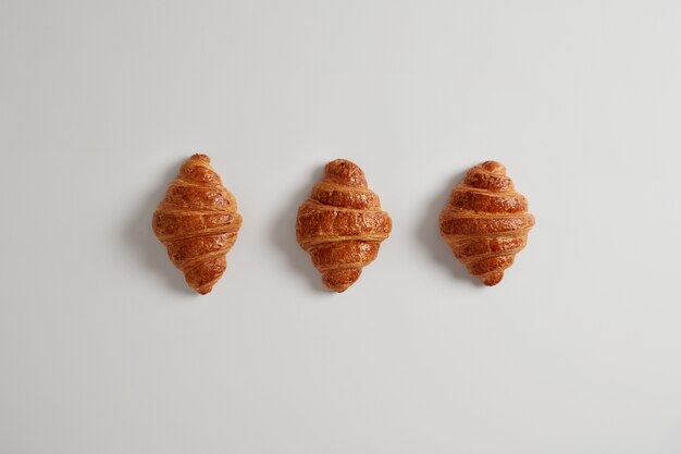 Drei köstliche Croissants mit Marmelade zum täglichen Frühstück. Traditionelles klassisches französisches Backprodukt. Vielzahl von hausgemachtem Blätterteig. Frische Süßwaren. Junk-Food- und Kalorienkonzept.