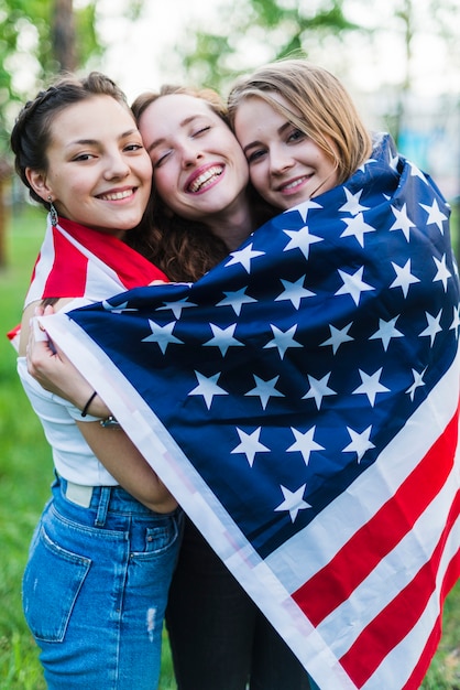 Drei Mädchen in der Natur mit amerikanischer Flagge