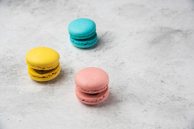 Drei mehrfarbige Macarons Nachtisch auf weißem Hintergrund.