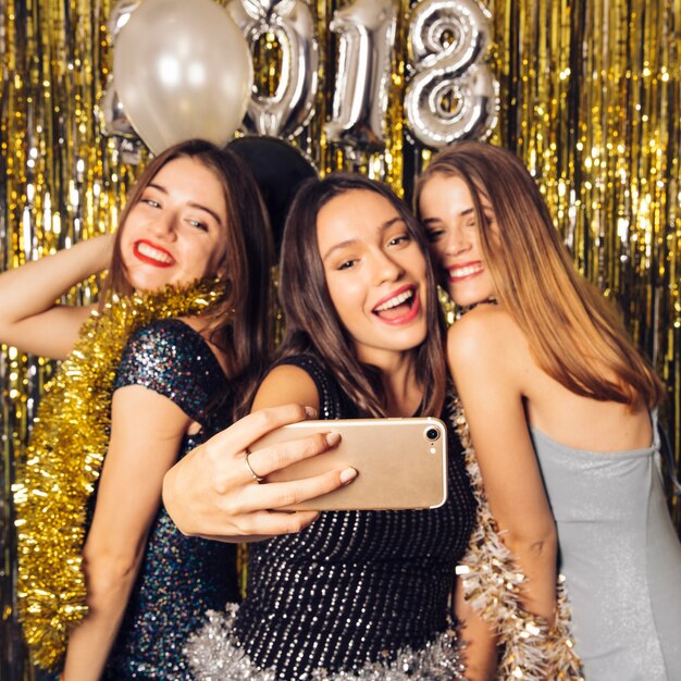 Drei Party-Mädchen nehmen Selfie auf Neujahrsfeier