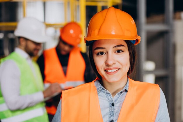 Drei Personen diskutieren in einer Fabrik über einen Plan