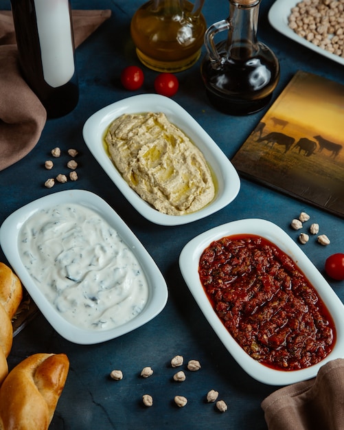 Kostenloses Foto drei platten mit türkischen beilagen werden im restaurant serviert