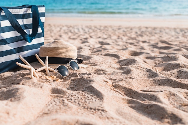 Drei Seesterne mit großer Tasche auf Sand