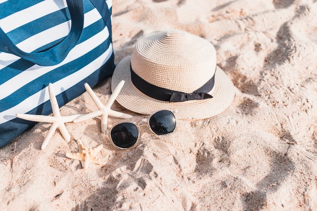 Drei Seesterne mit Tasche auf Sand