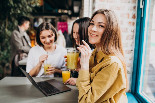 Drei Studenten, die für Prüfung mit Laptop in einem Café sich vorbereiten