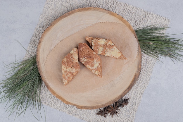 Drei süße Scheiben Kuchen mit Sternanis auf Holzteller. Hochwertiges Foto