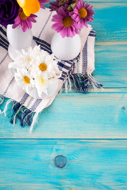 Drei Vasen mit hellen Blumen auf Holztisch