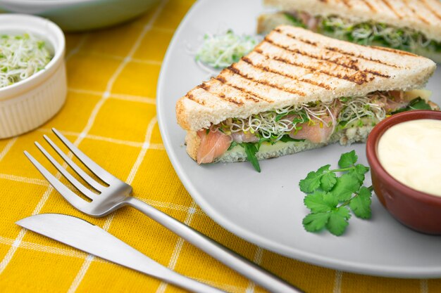 Dreieckige Sandwiches auf Teller mit Mayo und Besteck