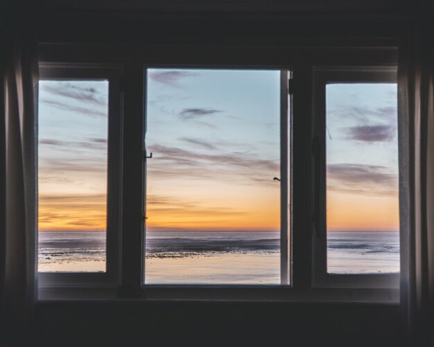 Dreifach getäfeltes Fenster mit herrlichem Blick auf den Sonnenuntergang draußen