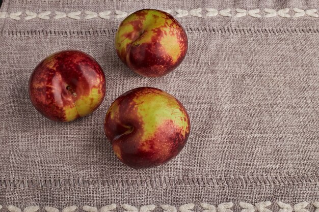 Dreifache rote Äpfel isoliert auf Küchentisch.