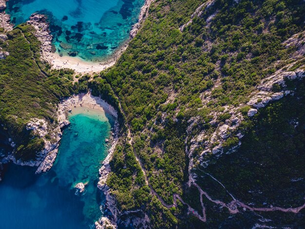 Drohnenaufnahme des atemberaubenden Ufers von Porto Timoni mit tiefem tropischen Blau und klarem türkisfarbenem Meer