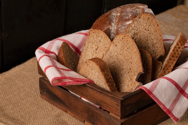 Dünne Brotscheiben in einem hölzernen Korb.