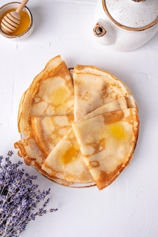 Dünne pfannkuchen mit honig. crpe auf einem teller. frühstückskonzept. ansicht von oben. Premium Fotos
