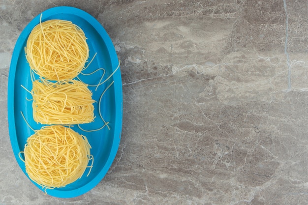 Kostenloses Foto dünne spaghetti-nester auf blauem teller