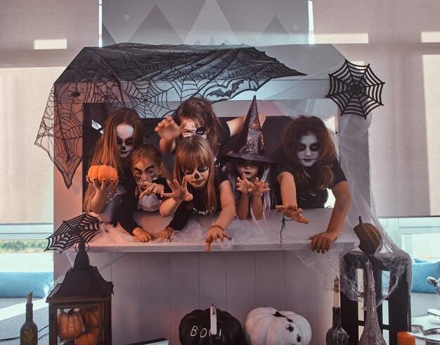 Düster ernste Kinder und Jugendliche in Halloween-Kostümen ziehen ihre Hände zur Kamera.
