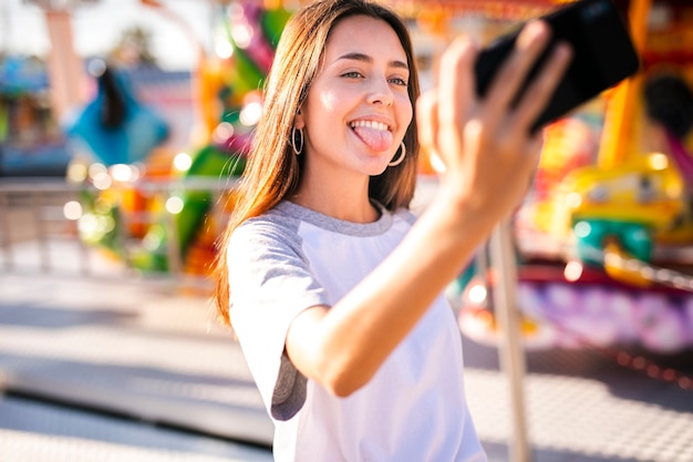 Kostenloses Foto dumme frau, die selfie mit telefon nimmt