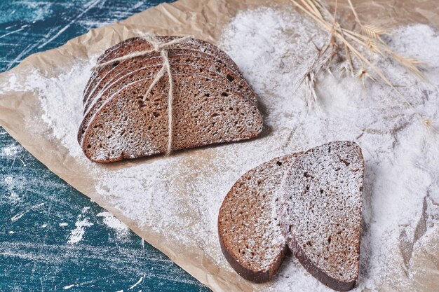 Dunkle Brotscheiben auf blauem Tisch.