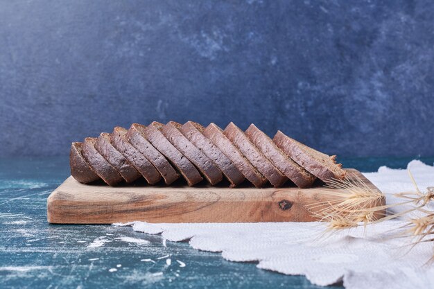 Dunkle Brotscheiben auf blauem Tisch.