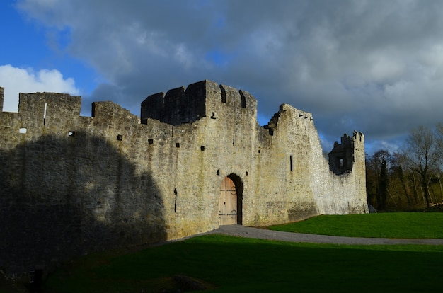 Dunkle Gewitterwolken über den Ruinen von Desmond Castle in Irland.