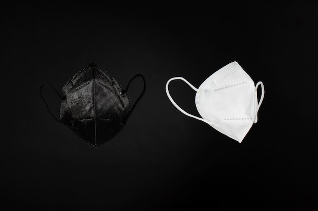 Dunkle und weiße ffp2-Masken mit dunklem Hintergrund