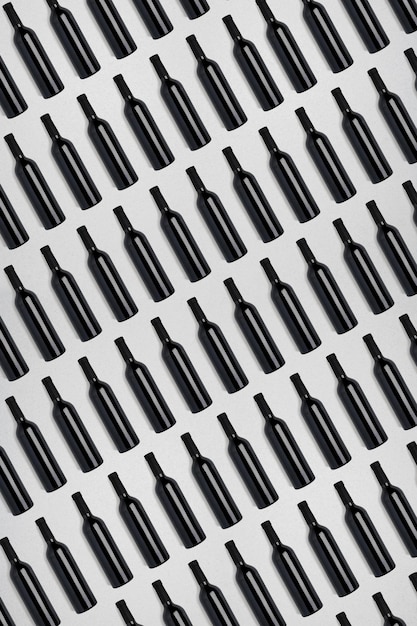Kostenloses Foto dunkle weinflaschen. kreativer dunkler und strukturierter abstrakter hintergrund. viele flaschen wein auf weißem hintergrund. muster