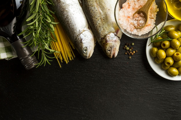 Dunkler Hintergrund mit Fisch und anderen Zutaten