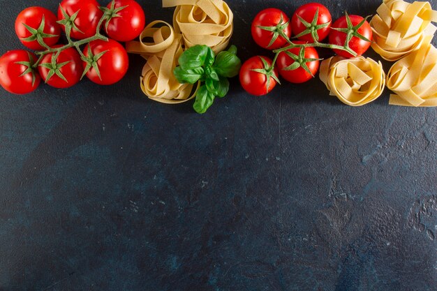 Dunkler Hintergrund mit Spaghetti und Tomaten