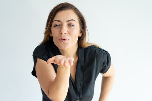 Durchbrennenkuß der netten hübschen jungen Frau zur Kamera.