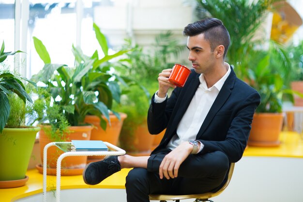 Durchdachter hübscher Geschäftsmann, der Kaffee genießt