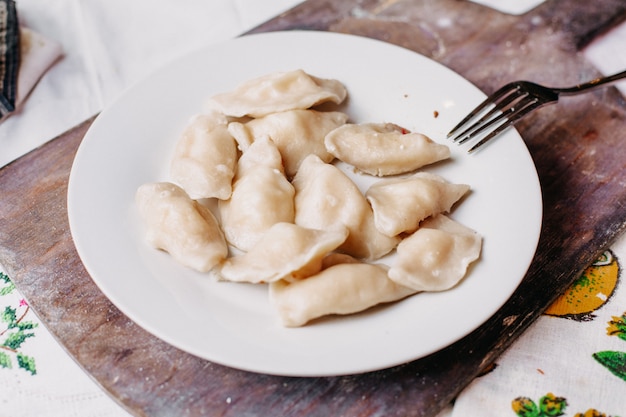 Dushpere Famoust Eastern Mahlzeit mit Teig in Hackfleisch gesalzen Pfeffer in weißen Teller gepfeffert