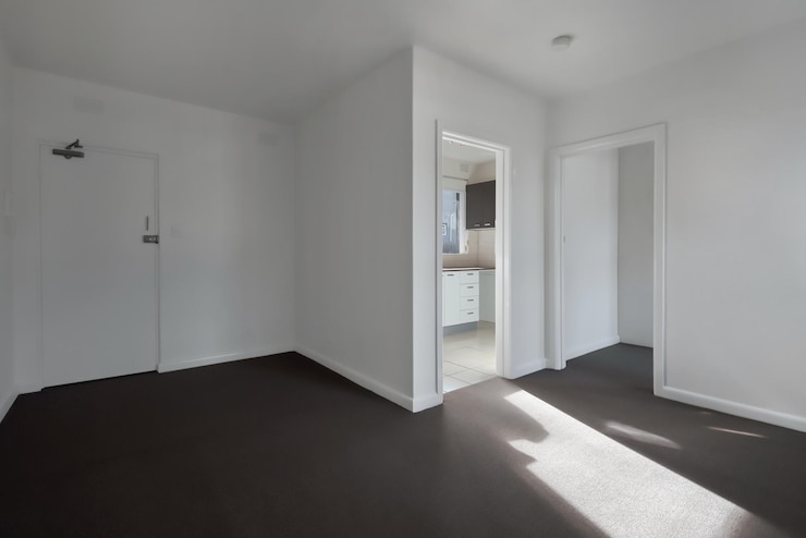 Kostenlose Foto ecke eines leeren neuen raums mit weißen wänden, türen und schwarzem boden