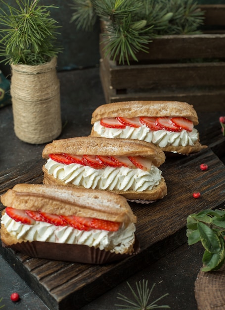 Eclairs mit schlagsahne und erdbeeren.