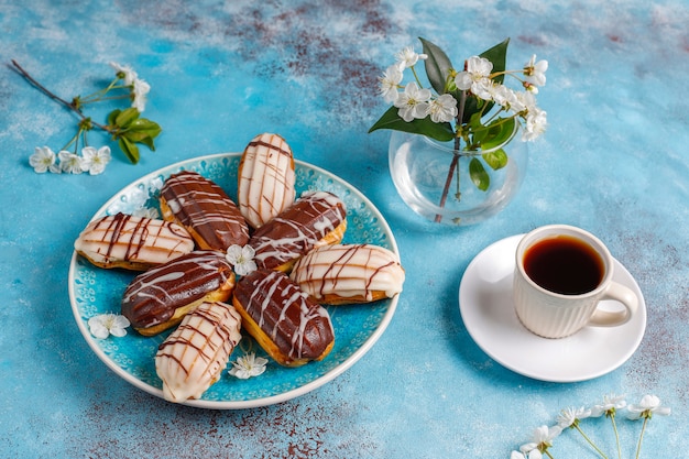 Eclairs oder Kränzchen mit schwarzer Schokolade und weißer Schokolade mit Pudding im Inneren
